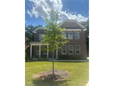 Charming brick home with a well-manicured lawn and a newly planted tree in the front yard at 565 Abbott Se Ct, Atlanta, GA 30354