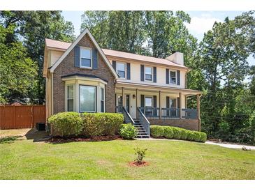Two-story brick home with covered porch and landscaped yard at 3664 Nessa Se Ct, Smyrna, GA 30082