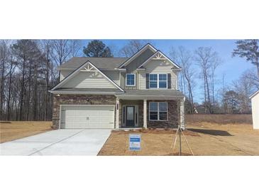 Charming two-story home with stone accents, a two-car garage, and a well-maintained front yard at 6045 Spring Way, Stonecrest, GA 30038