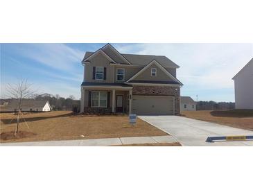 Two story home featuring stone accents, attached garage and a well manicured lawn at 6038 Spring Way, Stonecrest, GA 30038