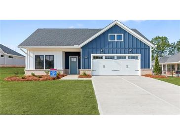 Charming blue and white home with a well-manicured lawn and an attached two car garage at 5245 Maggie Mae Ln, Cumming, GA 30028