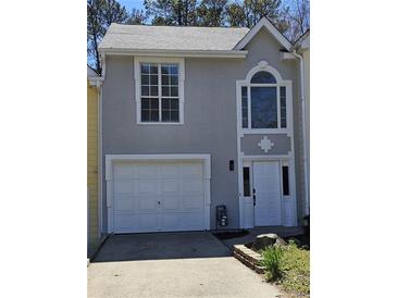 Charming home featuring a clean white garage door, elegant white trim, and stucco facade at 1041 Kennesborough Nw Rd, Kennesaw, GA 30144