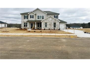 Two-story house with stone accents and a landscaped yard at 704 Hedwig Dr Lot 90, Mcdonough, GA 30252