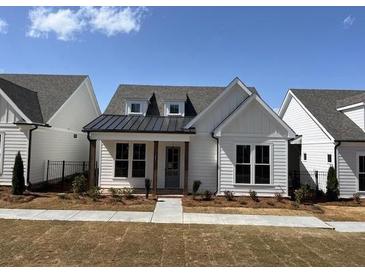 Charming single-story home featuring a black metal roof accent, white siding, and a well-maintained lawn at 505 Godfrey Dr, Cumming, GA 30040