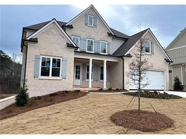 Two-story house with light brick exterior, gray shutters, and a landscaped lawn at 1077 Sweet Mia Ln, Powder Springs, GA 30127