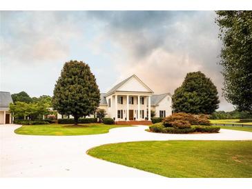 Elegant two-story home with a circular driveway and manicured lawn at 1875 Highway 142, Covington, GA 30014