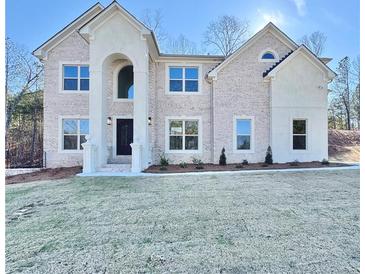 Two-story house with brick facade, arched entryway, and landscaped lawn at 179 Basie Ct, Fairburn, GA 30213