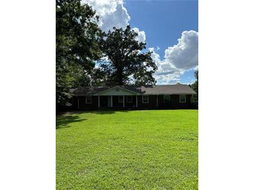 Brick ranch house with a large front yard and mature trees at 5595 Stagecoach Rd, Rex, GA 30273