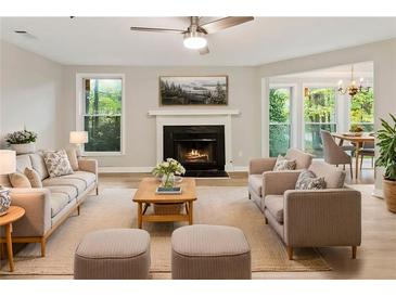 Inviting living room with a cozy fireplace, ceiling fan, and ample natural light at 4315 Orchard Park Ct, Stone Mountain, GA 30083