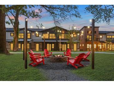 Inviting fire pit area with Adirondack chairs and string lights for relaxing evenings at 947 Willingham Dr # 2, Hapeville, GA 30354