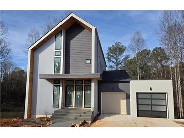 Modern two-story home with gray and white siding, attached garage, and landscaped yard at 165 Cedarwood Ln, Roswell, GA 30075