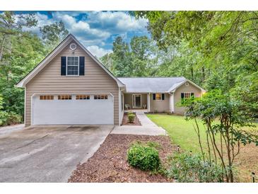 House exterior featuring a three-car garage and landscaped yard at 1720 Mineral Springs Rd, Hoschton, GA 30548