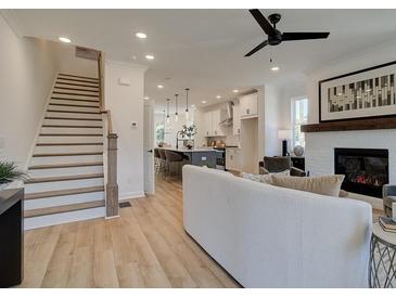 Open living room features a cozy fireplace and flows into the kitchen at 1996 Deco Dr, Kennesaw, GA 30144