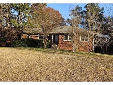 Charming single-story home featuring a brick facade and mature trees in a large, open front yard at 1417 Iris Lake Rd, Mcdonough, GA 30252