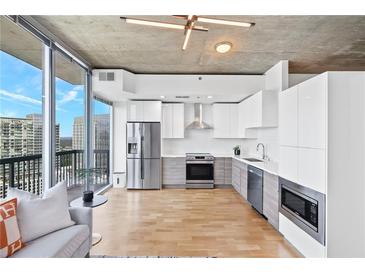 Modern kitchen featuring stainless steel appliances, white cabinetry, and a stunning city view at 3324 Peachtree Ne Rd # 2706, Atlanta, GA 30326