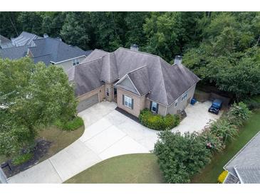 Aerial view of a spacious brick home with a large driveway and surrounding trees at 186 Thorn Creek Way, Dallas, GA 30157