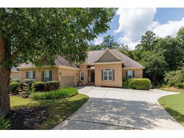 Charming brick home with manicured landscaping, large driveway, and attached two-car garage at 186 Thorn Creek Way, Dallas, GA 30157