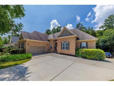 Charming brick home featuring a two-car garage, well-manicured landscaping, and a long driveway at 186 Thorn Creek Way, Dallas, GA 30157