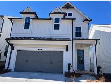 Charming two-story home featuring a two-car garage, a covered entryway and a light-colored facade at 635 Skytop Dr, Cumming, GA 30040