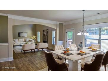 Bright dining room and living room with hardwood floors and ample natural light is great for entertaining guests at 932 Nestling Dr, Lawrenceville, GA 30045