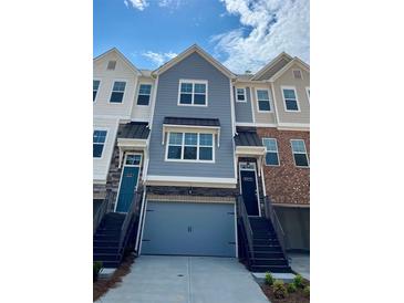 Charming townhome exterior featuring varied textures, private entrances, and attached garages at 2539 Hedgeway Cir, Kennesaw, GA 30144