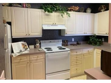 Bright kitchen features a white stove, white cabinets, and a neutral countertop at 3334 Peachtree Ne Rd # 1110, Atlanta, GA 30326