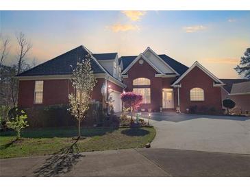 Charming brick home featuring an attached garage, lush landscaping, and a welcoming driveway at 3240 Somerset Se Ct, Conyers, GA 30013