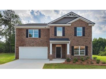 Brick two-story house with a white garage door and landscaping at 4107 Spencer Trl, Stonecrest, GA 30038