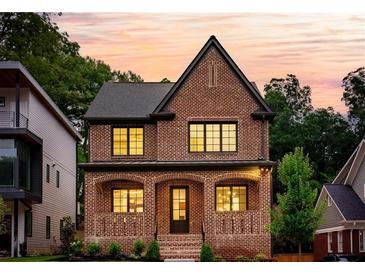 Stunning two-story brick home featuring large windows, manicured landscaping, and a classic, elegant design at 1277 Avalon Ne Pl, Atlanta, GA 30306