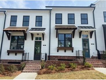 Charming two-story townhomes with brick accents and well-manicured lawns, offering a welcoming curb appeal at 628 Skytop Dr # 158, Cumming, GA 30040