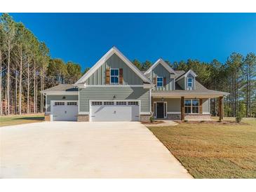 Two-story house with three-car garage and wood accents at 125 Pinewood Dr, Covington, GA 30014