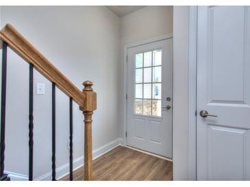 Welcoming entryway with wood-look floors and a glass paneled front door, complemented by an oak handrail and wrought iron balusters at 3405 Ripple Loop # 127, South Fulton, GA 30349