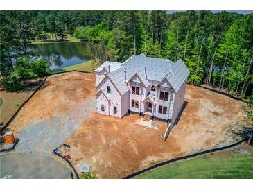 A partially completed two-story home is on a large lot with lake views, surrounded by mature trees at 2675 Drayton Hall Dr, Buford, GA 30519