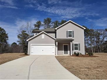Charming two-story home with a two-car garage, landscaped yard, and a long concrete driveway at 8659 Paradise Dr, Douglasville, GA 30134