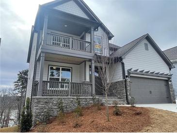 Two-story home with gray siding, stone accents, and a two-car garage at 366 Boundless Ln, Canton, GA 30114