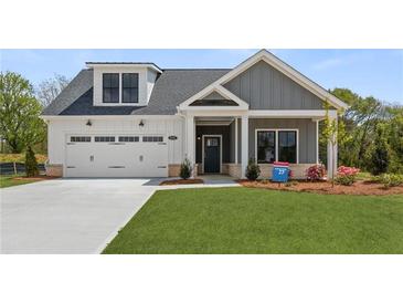 Charming home with a two-car garage, gray siding and a beautifully landscaped yard at 5210 Ginger Rose Ct, Cumming, GA 30028