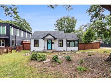 Charming white cottage with black trim and a manicured lawn at 980 Moreland Se Ave, Atlanta, GA 30316