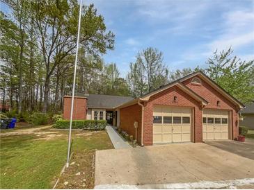 Charming brick home featuring a two-car garage and a well-manicured lawn at 7131 Forest Ln, Union City, GA 30291