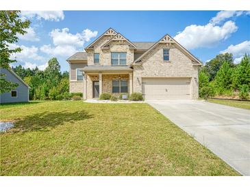Charming two-story home featuring brick facade, well-manicured lawn, and an attached two-car garage at 3201 Camden Ct, Atlanta, GA 30349