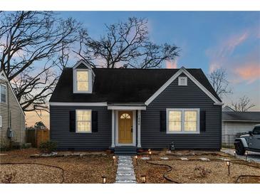Charming home with gray siding, black shutters, a welcoming yellow front door, and landscape lighting at 1466 Hardin Ave, Atlanta, GA 30337