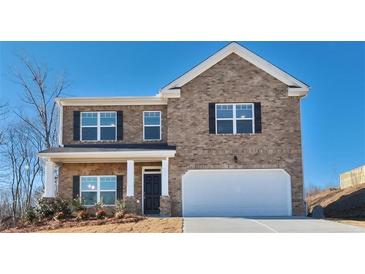 Two-story brick home with a white garage door and landscaping at 4084 Spencer Trl, Stonecrest, GA 30038