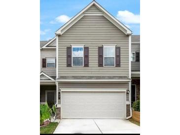 Tan two-story townhome with white garage door and dark brown shutters at 21 Crescent Chase Dr, Dallas, GA 30157