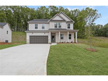Charming two-story home with a two-car garage, manicured lawn, and inviting front porch at 404 Beacon Way, Villa Rica, GA 30180