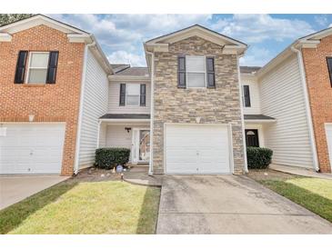 Charming townhome with a stone facade and a one-car garage and well maintained front lawn at 6693 Villa Ct # 6693, Lithonia, GA 30038