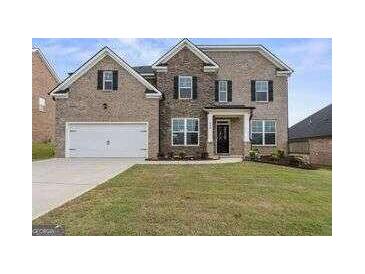 Two-story brick home with a well-maintained front yard and attached two-car garage at 916 Dexter Dr, Stockbridge, GA 30281