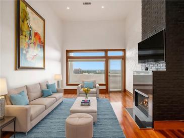 Bright living room featuring high ceilings, a fireplace, and beautiful hardwood floors at 3334 Peachtree Ne Rd # 1707, Atlanta, GA 30326