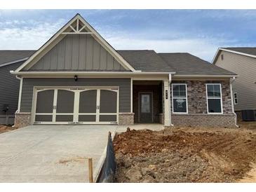 Charming single-story home featuring a two-car garage and mixed material facade at 615 Moorhen Way, Loganville, GA 30052