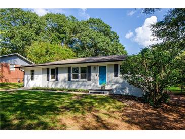 Charming one-story home with a well-manicured lawn, blue door, and a freshly painted white brick facade at 123 Arnold Pl, Jonesboro, GA 30236