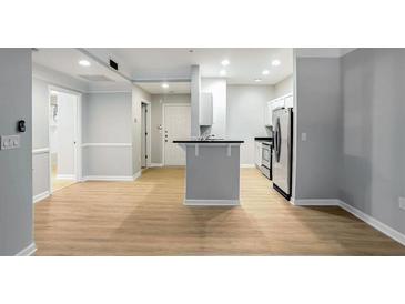 Spacious living room with hardwood floors leading to a modern kitchen featuring stainless steel appliances at 2700 Pine Tree Ne Rd # 1007, Atlanta, GA 30324