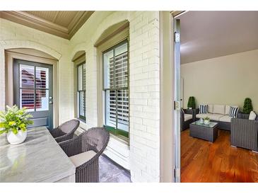 Inviting front porch with seating area and view into a cozy sunroom with hardwood floors at 3127 Lenox Road # 6, Atlanta, GA 30324